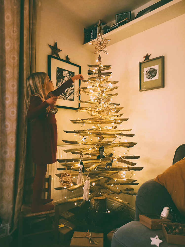 Zoe decorating an Eco Christmas Tree.